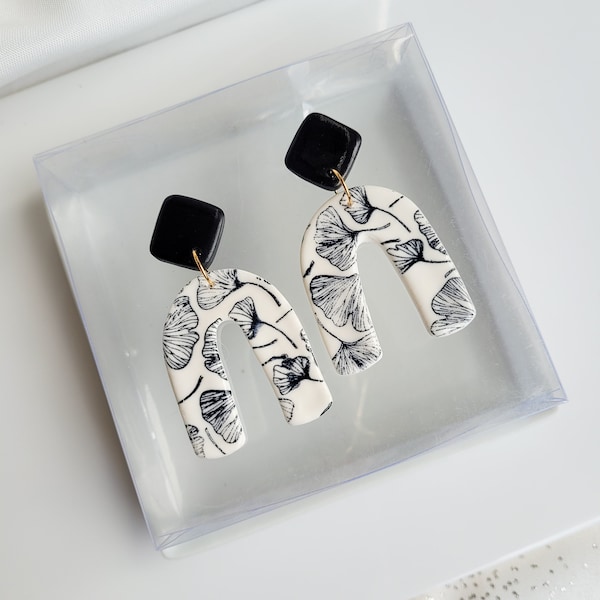 Boucles d'oreilles blanches et motifs feuilles de Gingko noirs, faits main en France en argile polymère. Création artisanale unique