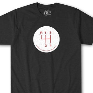Op de afbeelding: Een donkergrijs t-shirt met een witte cirkelvormige afbeelding met een rood schakelpatroon. De tekst "FRIDAY NIGHT RICH EQUIPMENT" staat rond de cirkel.