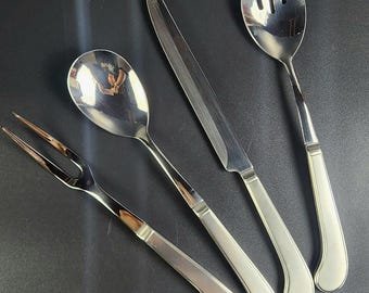 May include: A set of four silver-toned kitchen utensils with curved handles. The set includes a fork, a spoon, a knife, and a serving fork.