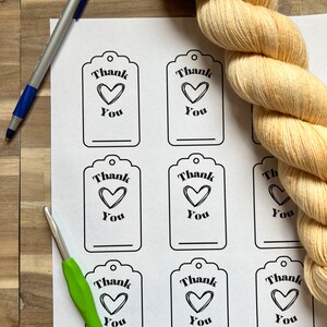 May include: Eight printable gift tags with a black and white design. Each tag features the text "Thank You" with a heart symbol. The tags are printed on white paper.