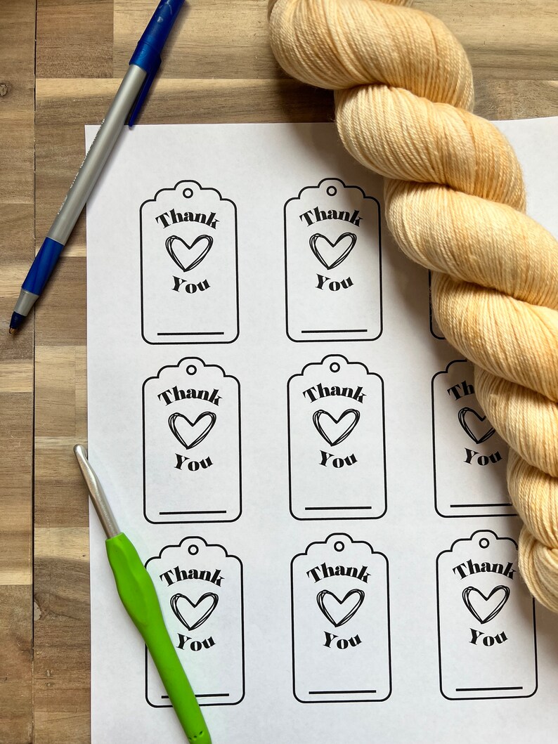 May include: Eight printable gift tags with a black and white design. Each tag features the text "Thank You" with a heart symbol. The tags are printed on white paper.
