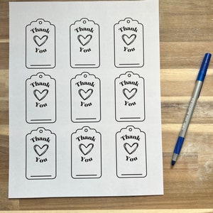 May include: Nine printable gift tags with a black and white design. Each tag features a heart with the text "Thank You".