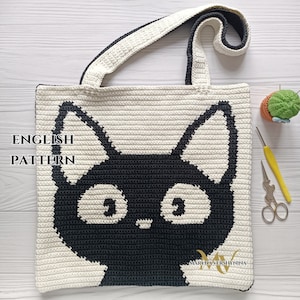 Könnte beinhalten: Garn-Tragetasche mit einem schwarzen Katzenkopf-Design. Die Tasche hat einen weißen Hintergrund und einen schwarzen Besatz. Der Text "ENGLISH PATTERN" ist auf der Tasche sichtbar.