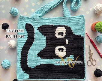 May include: A crocheted tote bag with a black cat design. The bag is light blue with white accents for the cat's eyes. The bag has a black handle and the text "ENGLISH PATTERN" is visible in the image.
