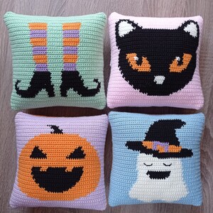 May include: Four crocheted pillow covers with Halloween themes. The first pillow cover is green with a pair of witch's legs and shoes. The second pillow cover is pink with a black cat. The third pillow cover is purple with a jack-o-lantern. The fourth pillow cover is blue with a ghost wearing a witch's hat.