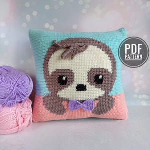 May include: Crochet pattern for a sloth pillow. The pillow is made with light blue, pink, brown, and purple yarn. The sloth has a bow tie and a cute expression. The pattern is available as a PDF download.