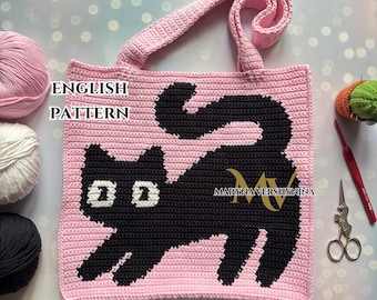 Op de afbeelding: Roze gehaakte tote bag met een zwart kattenontwerp. De tas heeft een enkele band en de tekst "ENGLISH PATTERN" is zichtbaar aan de voorkant.