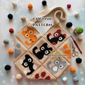 May include: A beige crocheted tote bag featuring cat designs in orange, black, and gray. The bag has a long strap and is surrounded by colorful yarn balls. The text "ENGLISH PATTERN" is visible on the bag.