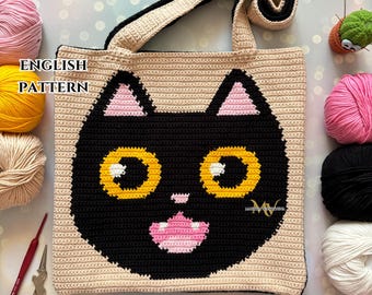 Op de afbeelding: Gehaakte tote bag met een zwart kattengezicht met gele ogen en een roze neus. De tas is gemaakt van beige en zwart garen. De tekst "ENGLISH PATTERN" is zichtbaar in de linkerbovenhoek van de afbeelding.