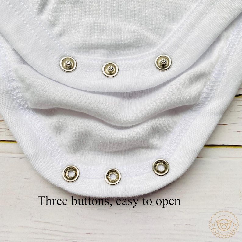 May include: Close-up of a white baby bodysuit with three popper fastenings. The text "Three buttons, easy to open" is printed at the bottom. The bodysuit is made of soft, white fabric.