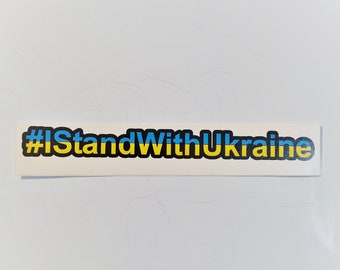 Może przedstawiać: Prostokątna naklejka z napisem "#IStandWithUkraine" w kolorze niebieskim i żółtym, barwach ukraińskiej flagi, na białym tle. Naklejka jest symbolem wsparcia i solidarności.