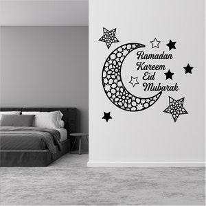 May include: Black and white wall decal featuring a crescent moon with intricate geometric patterns and five stars. The text "Ramadan Kareem Eid Mubarak" is written in a decorative font.