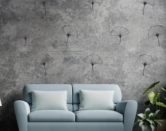 May include: A light blue sofa with two pillows sits in front of a gray concrete wall with black ginkgo leaf decals.