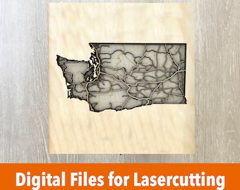 May include: A laser-cut wooden map of the state of Washington, showing the state's counties and major roads. The map is on a light brown wooden background.