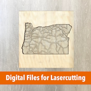 May include: A wooden laser-cut map of Oregon, featuring detailed road and city outlines. The map is set on a light-colored wooden square. The words "Digital Files for Lasercutting" are displayed in an orange banner at the bottom.