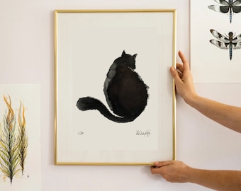 Puede incluir: Una pintura de acuarela en blanco y negro enmarcada de un gato sentado con la cola enroscada alrededor de su cuerpo. La pintura está firmada "W. Seagroves" y numerada "1/50".