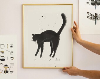 Puede incluir: Una ilustración en blanco y negro de un gato saltando en el aire, enmarcada en un marco dorado. La ilustración está sobre un fondo blanco con puntos negros.