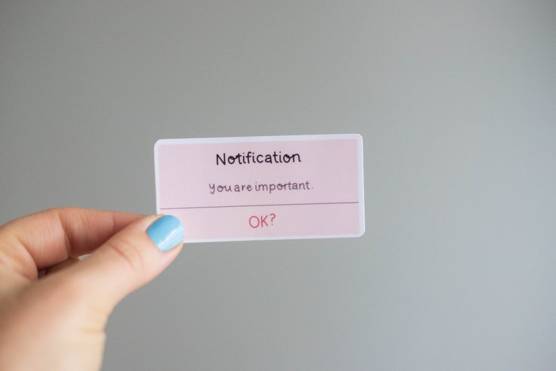 May include: A pink and white card with the text "Notification" and "You are important."  The card also has the text "OK?" on it.