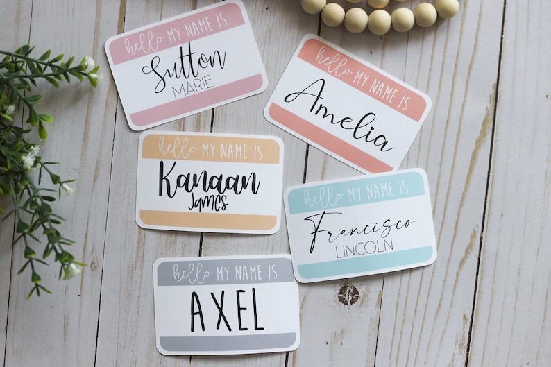 May include: Five colorful name tags with the text "hello my name is" and a name in cursive. The names are Sutton Marie, Kanaan James, Axel, Amelia, and Francisco Lincoln.