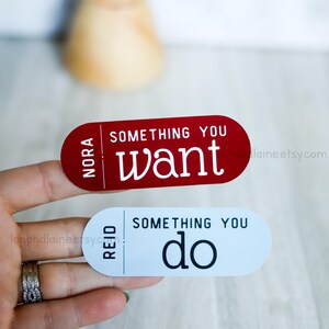May include: Two red and white rectangular stickers with the text "Something you want" and "Something you do" on them. The stickers have the names "Nora" and "Reid" on them.