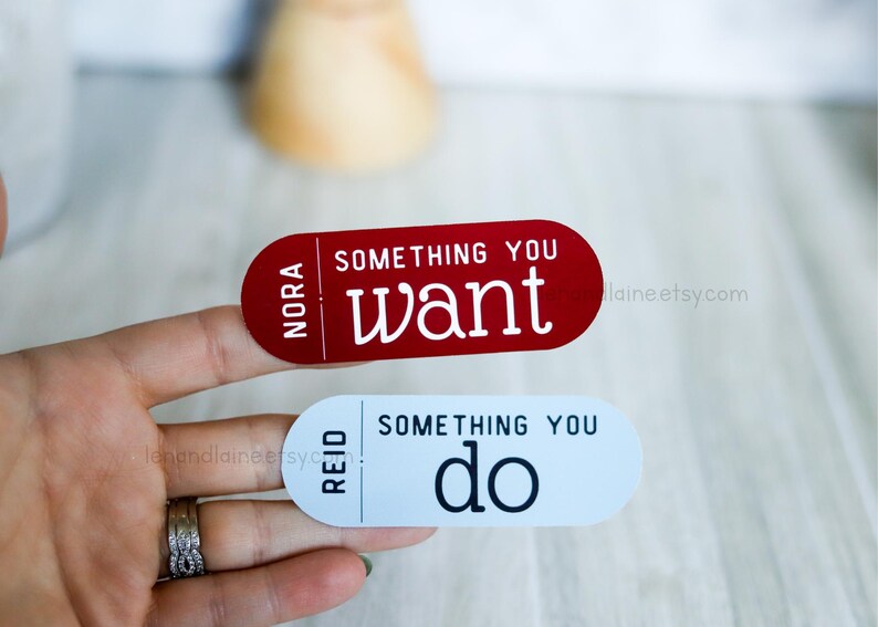 May include: Two red and white rectangular stickers with the text "Something you want" and "Something you do" on them. The stickers have the names "Nora" and "Reid" on them.