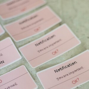 May include: Pink notification cards with the text "Notification You are important. OK?" repeated on each card.