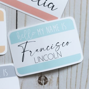 May include: A blue and white name tag with the text "hello my name is Francisco LINCOLN" in black cursive writing.