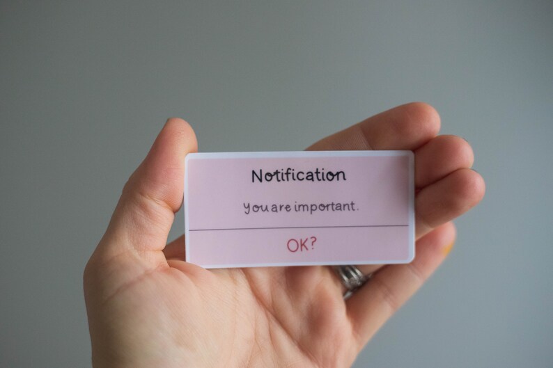 May include: A pink notification card with white text that reads "Notification" and "You are important."  The card also has the text "OK?" in red.
