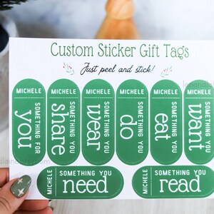 May include: Green sticker gift tags with the text "Custom Sticker Gift Tags" and "Just peel and stick!" printed on a white background. The tags are labeled with the name "Michele" and the words "you", "share", "wear", "do", "eat", "want", "need", and "read".