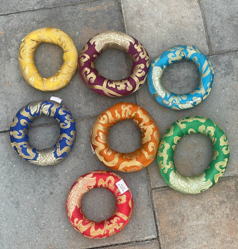 Puede incluir: Siete cojines de meditaci&oacute;n coloridos, cada uno con un patr&oacute;n y un color diferente. Los cojines son redondos y tienen un agujero en el centro. Est&aacute;n hechos de tela y tienen una textura suave y c&oacute;moda.