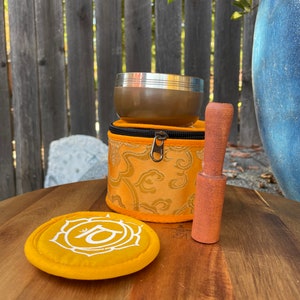 Puede incluir: Un conjunto de cuencos cantores para la meditaci&oacute;n y la relajaci&oacute;n. El conjunto incluye un cuenco cantor dorado, un mazo de madera y un coj&iacute;n amarillo con un s&iacute;mbolo impreso en &eacute;l.