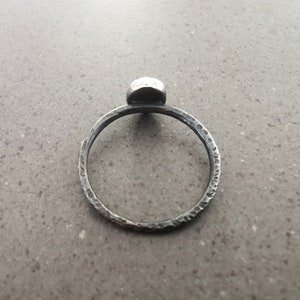 May include: A silver ring with a textured band and a round, hammered silver top.