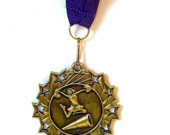 May include: A gold-colored medal with a cheerleading figure holding pom-poms and a megaphone. The medal is surrounded by a circle of stars and is attached to a purple ribbon.