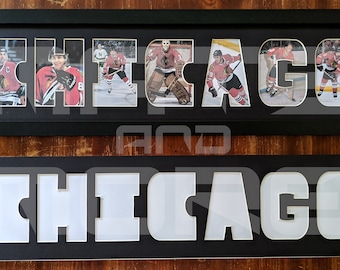 Pode incluir: Duas molduras pretas com um passe-partout branco. A moldura superior apresenta uma colagem de jogadores de hóquei formando a palavra "CHICAGO". A moldura inferior tem a palavra "CHICAGO" recortada em branco.