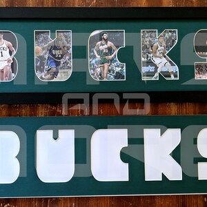 May include: A framed green and white sign with the word "BUCKS" spelled out in large white letters. Each letter is filled with a different photo of a basketball player wearing a green and white uniform.