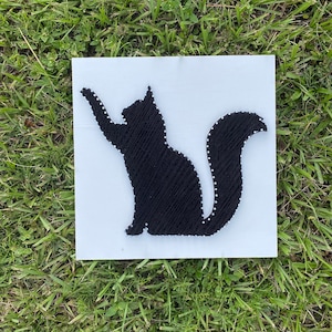 Könnte beinhalten: Schwarze Katzensilhouette, die mit String Art auf weißem Hintergrund erstellt wurde.