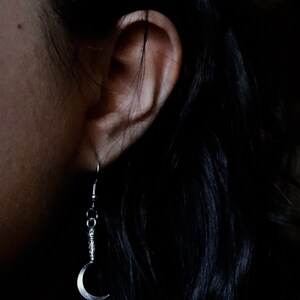 a pair of sickle/scythe earrings for herbalists and witches.