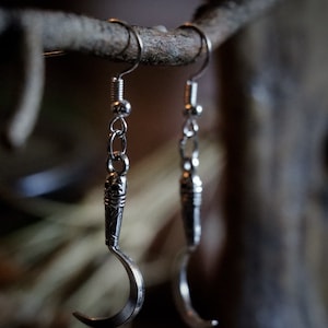 a pair of sickle/scythe earrings for herbalists and witches.
