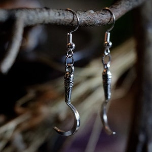 a pair of sickle/scythe earrings for herbalists and witches.
