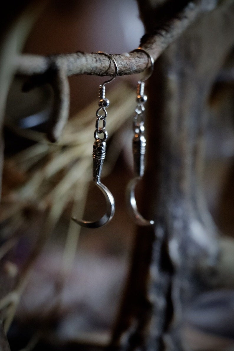a pair of sickle/scythe earrings for herbalists and witches.