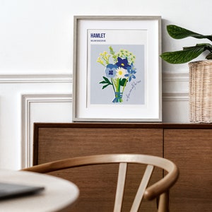 Puede incluir: Una impresi&oacute;n enmarcada de un ramo de flores azules y blancas con acentos amarillos. La impresi&oacute;n se titula "HAMLET" e incluye el texto "a flower only for the wise".