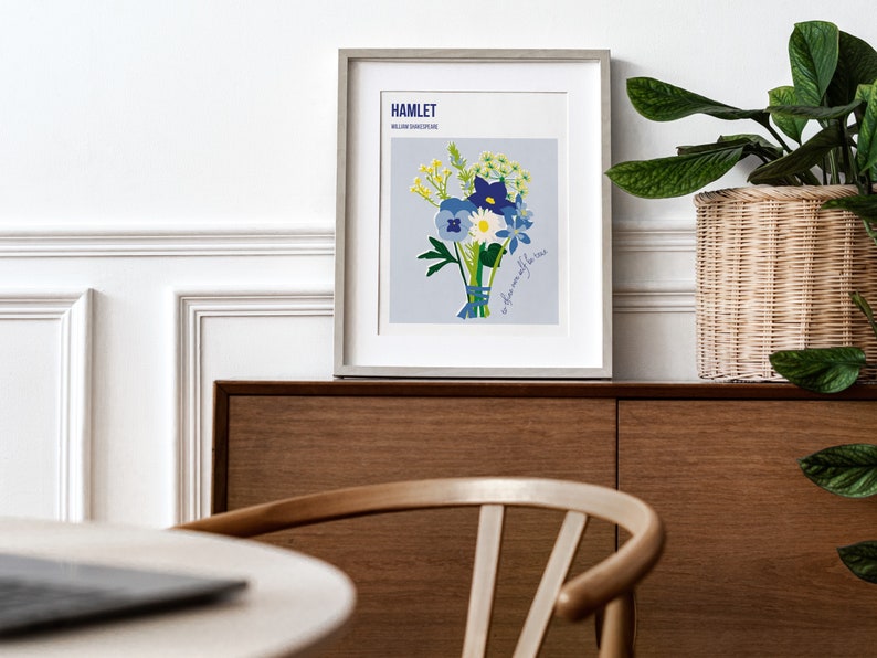 Puede incluir: Una impresi&oacute;n enmarcada de un ramo de flores azules y blancas con acentos amarillos. La impresi&oacute;n se titula "HAMLET" e incluye el texto "a flower only for the wise".