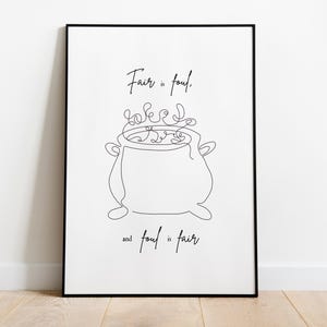 Op de afbeelding: Een ingelijste print met een minimalistische lijntekening van een ketel en de tekst "Fair is foul, and foul is fair" in een handschriftstijl. Het kunstwerk is in zwart en wit.