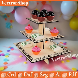 May include: A three-tiered wooden cake stand with decorative cut-out edges. The stand holds cupcakes, candies, and small, round, dark-coloured objects. The background includes balloons and confetti. The VectorShop logo is visible.