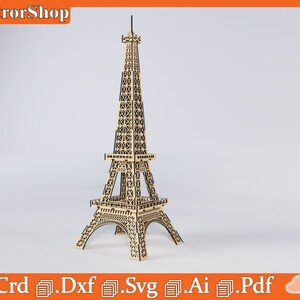 Puede incluir: Un modelo de madera de la Torre Eiffel, un famoso monumento de Par&iacute;s, Francia. El modelo est&aacute; hecho de madera cortada con l&aacute;ser y est&aacute; dise&ntilde;ado para ser ensamblado. El modelo se muestra sobre un fondo blanco.