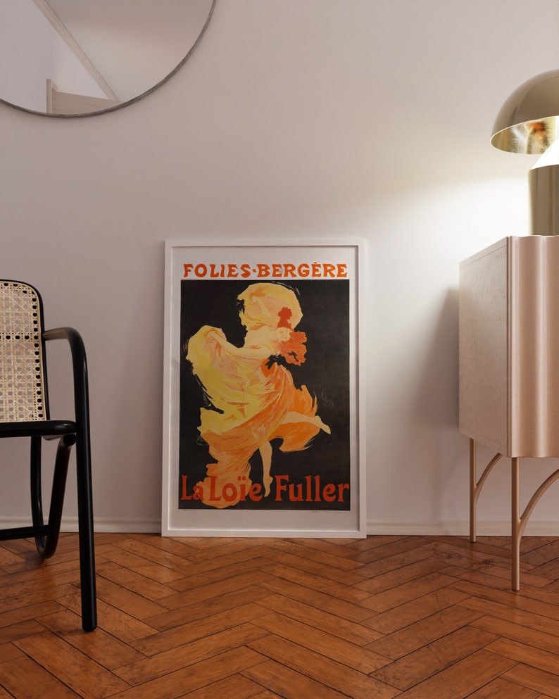 May include: A framed vintage poster advertising the Folies-Berg&egrave;re with a black background and a woman in a yellow and orange dress dancing. The text on the poster reads "Folies-Berg&egrave;re" and "La Lo&iuml;e Fuller".