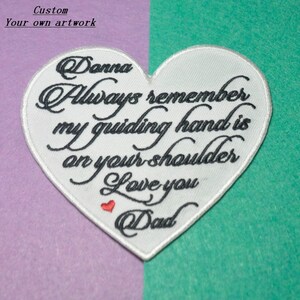 Puede incluir: Parche blanco en forma de corazón con texto bordado en negro que dice "Danna Always remember my guiding hand is on your shoulder Love you Dad".