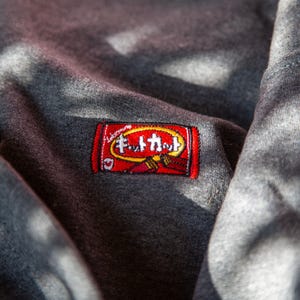 May include: Gray sweatshirt with a red embroidered patch that says "F.U.T.A.M.A."