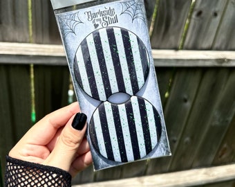 May include: Two black and white striped round coasters with green glitter. The coasters are packaged in a clear plastic bag with a white label that says "Darkside of my Soul".
