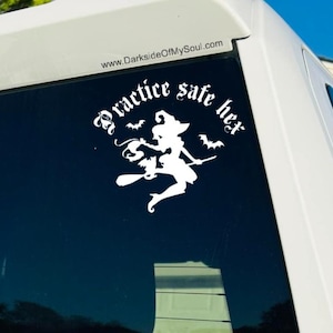 Puede incluir: Pegatina de vinilo blanco con una silueta de una bruja volando en una escoba con murciélagos. El texto "Practice safe hex" está escrito en una fuente gótica alrededor de la bruja.